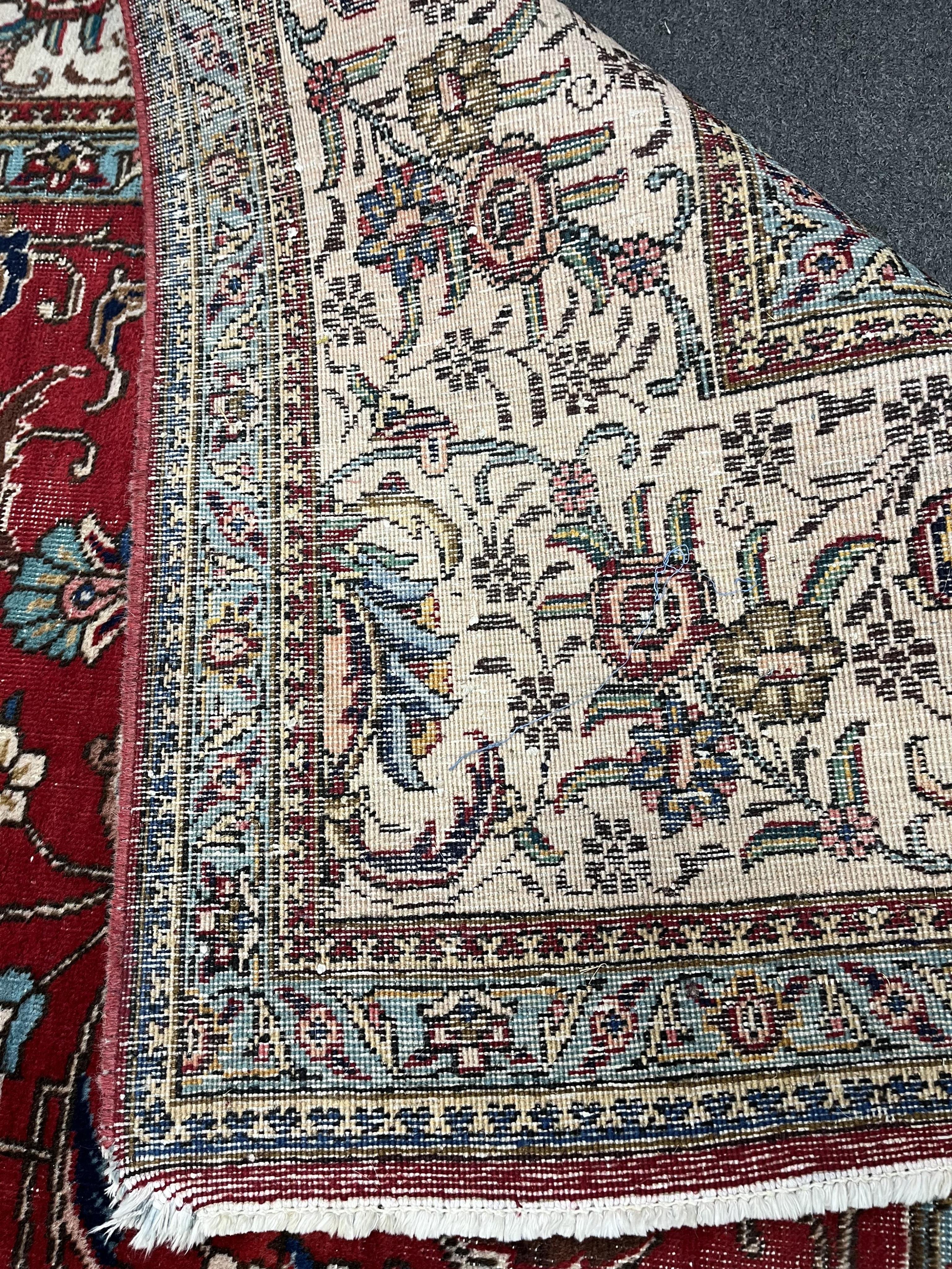 A Persian red ground carpet, worn, 340 x 340cm. Condition - fair